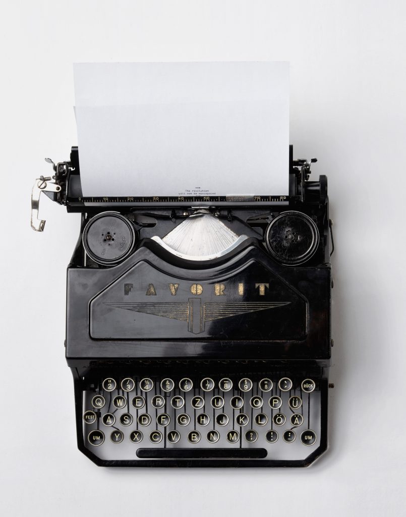 Old typewriter with a blank piece of paper ready to be typed for newsletters.
